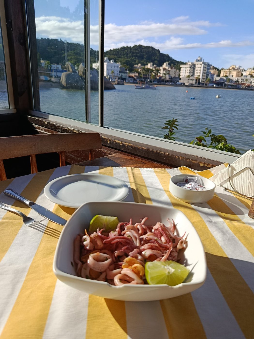 Lula alho e óleo com limão, na mesa ao lado da janela com vista para o mar