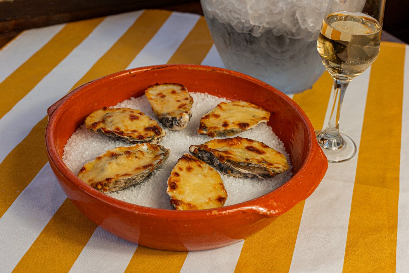 Ostras gratinadas. Gratinadas no forno, servidas no sal grosso