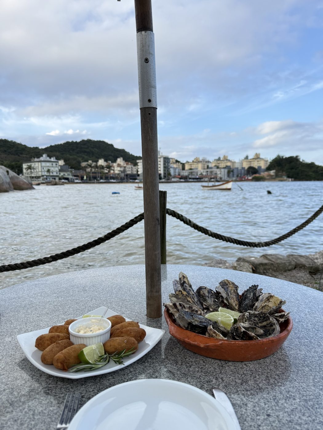 Bolinhos e ostras na orla. Petiscos para dividir de frente para o mar