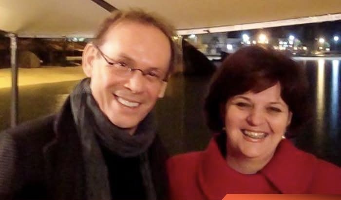 O ator José Wilker com a Cuca à noite, com a orla iluminada ao fundo